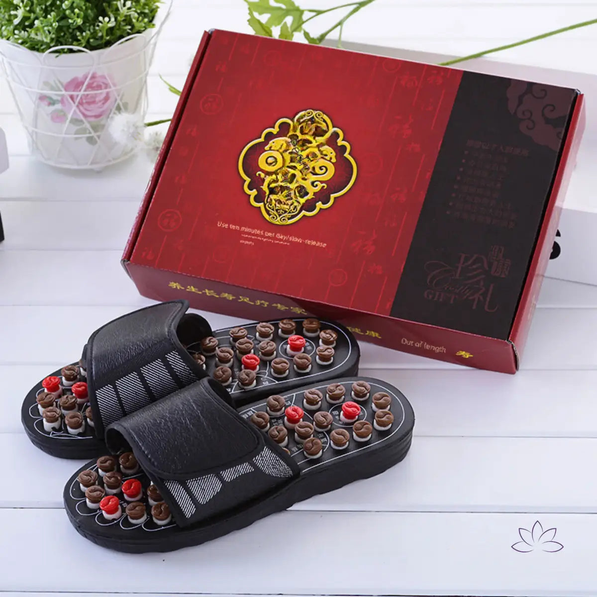 Chinelos VitalFeet massageadores expostos com caixa vermelha elegante ao fundo.