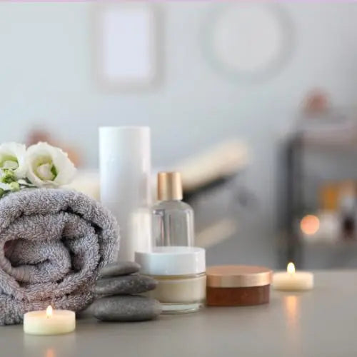 Toalhas, velas e óleos essenciais criando um ambiente de spa em casa, perfeito para relaxamento e autocuidado.