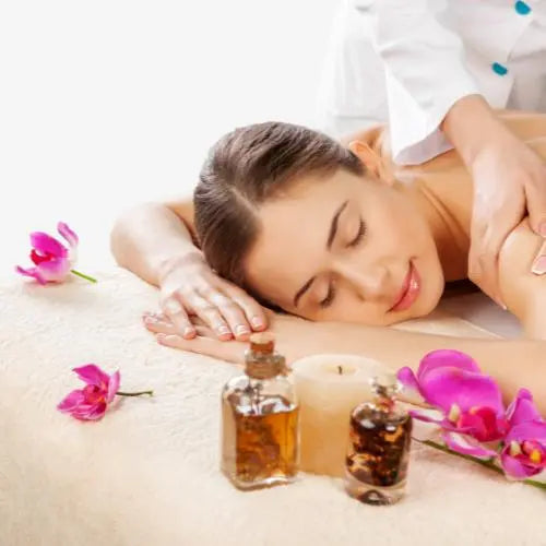 "Mulher relaxando com flores e óleos essenciais, representando autocuidado e bem-estar.