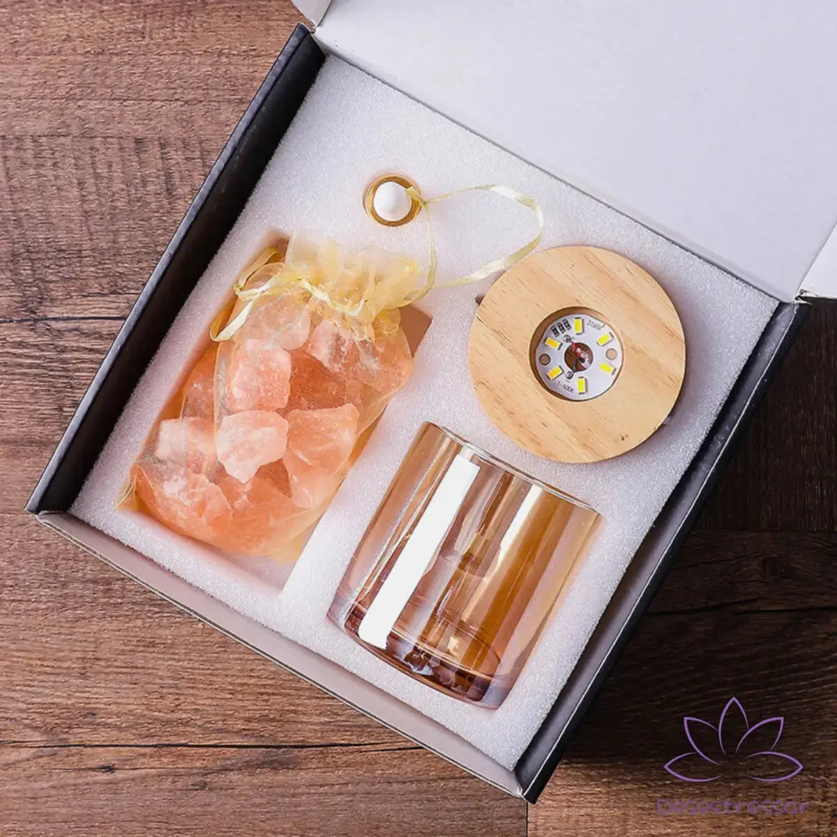 Conteúdo do kit AromaLuz: difusor de cristal, base de madeira, óleo essencial e manual de instruções, apresentados de forma organizada.