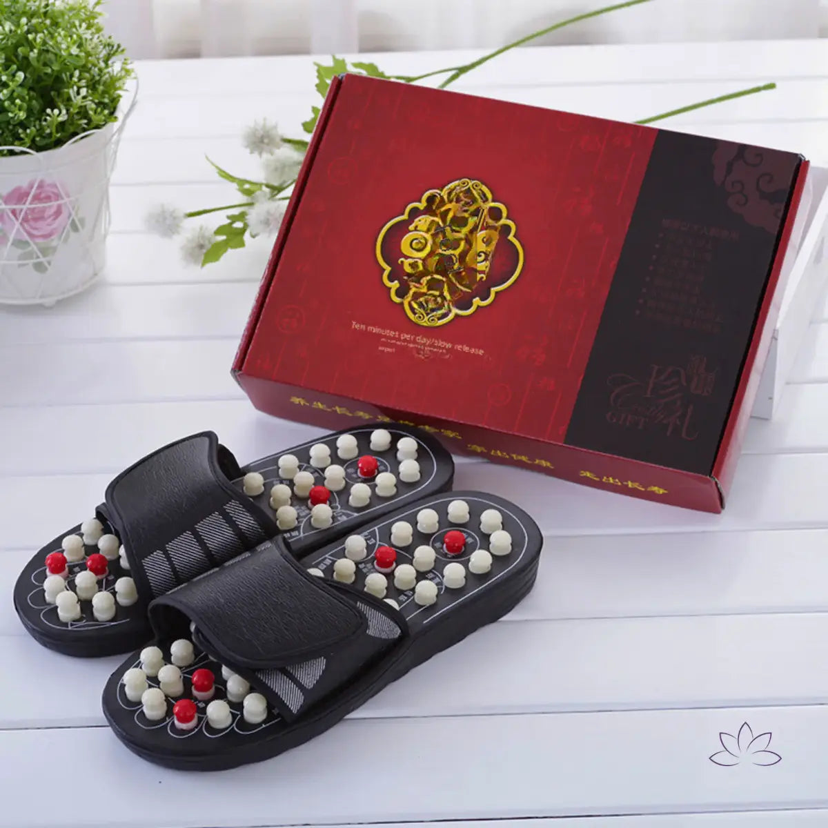 Chinelos VitalFeet ao lado de caixa vermelha decorativa, apresentados como opção de presente.